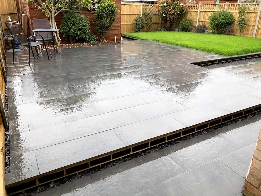 Dark stone effect porcelain paved patio with slip resistant finish by AWBS Landscaping